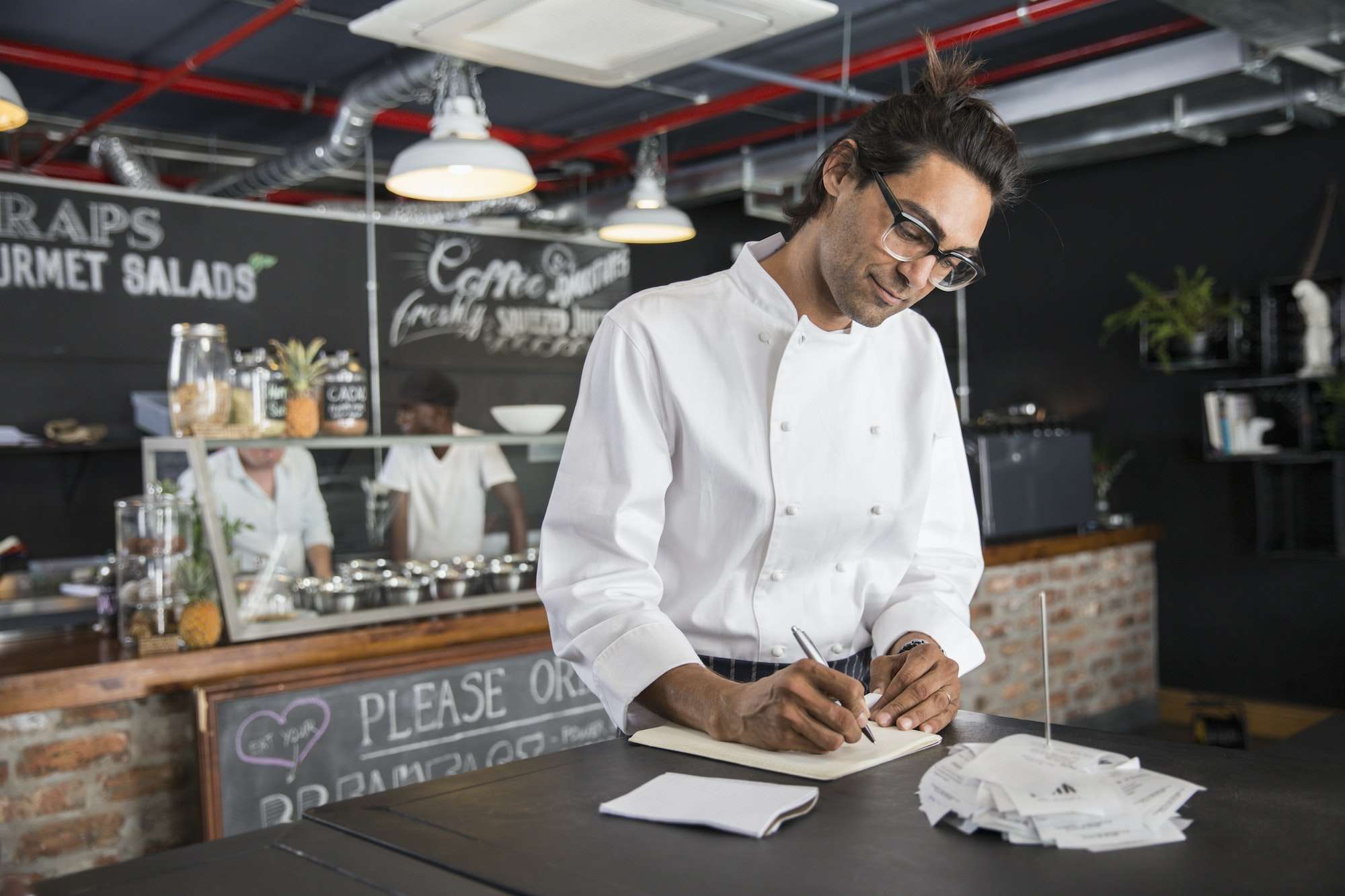 Chef in restaurant writing in notepad